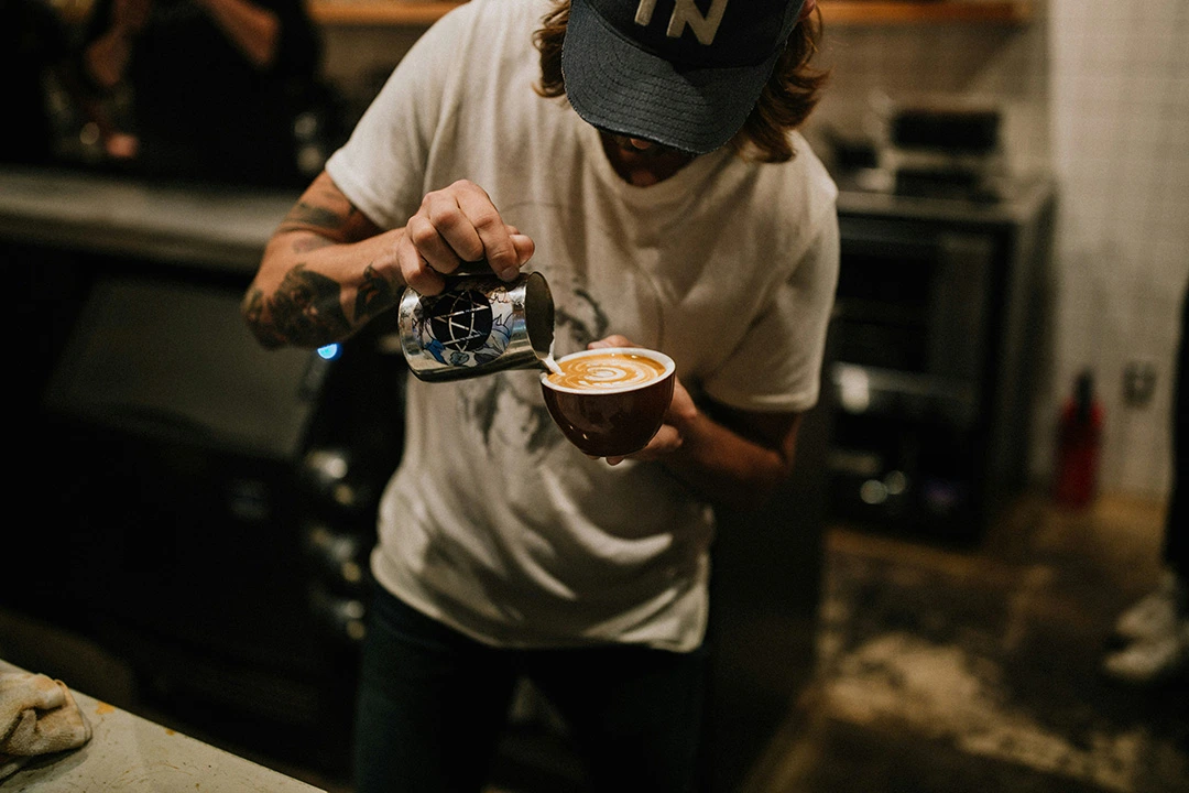 barista pouring latte at a doodle café in windsor